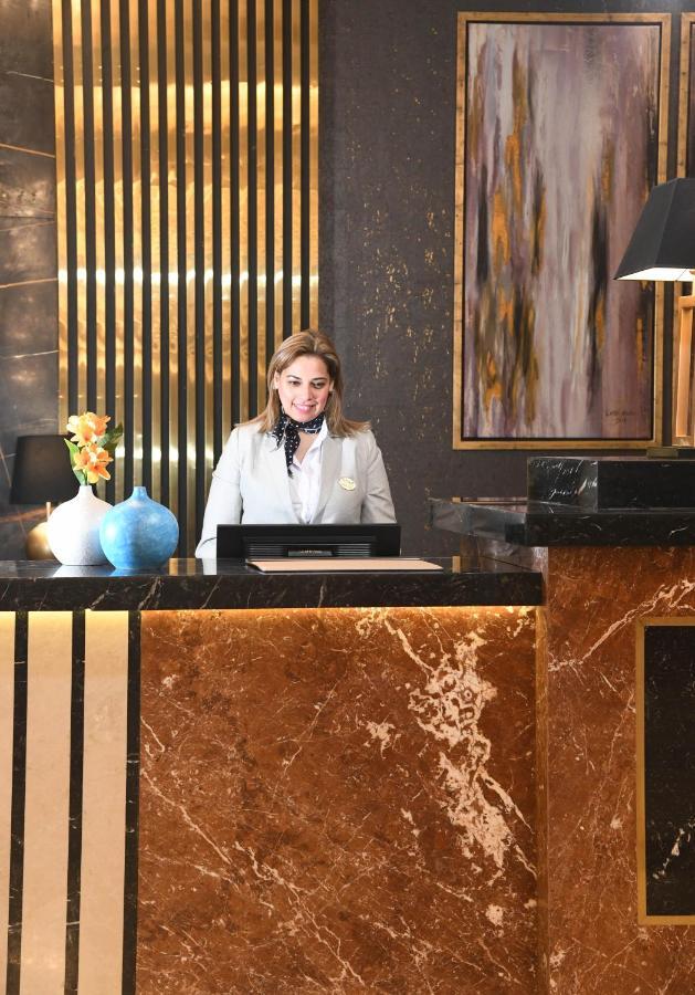 Tolip Gardens Hotel Кайро Екстериор снимка A hotel receptionist at the front desk